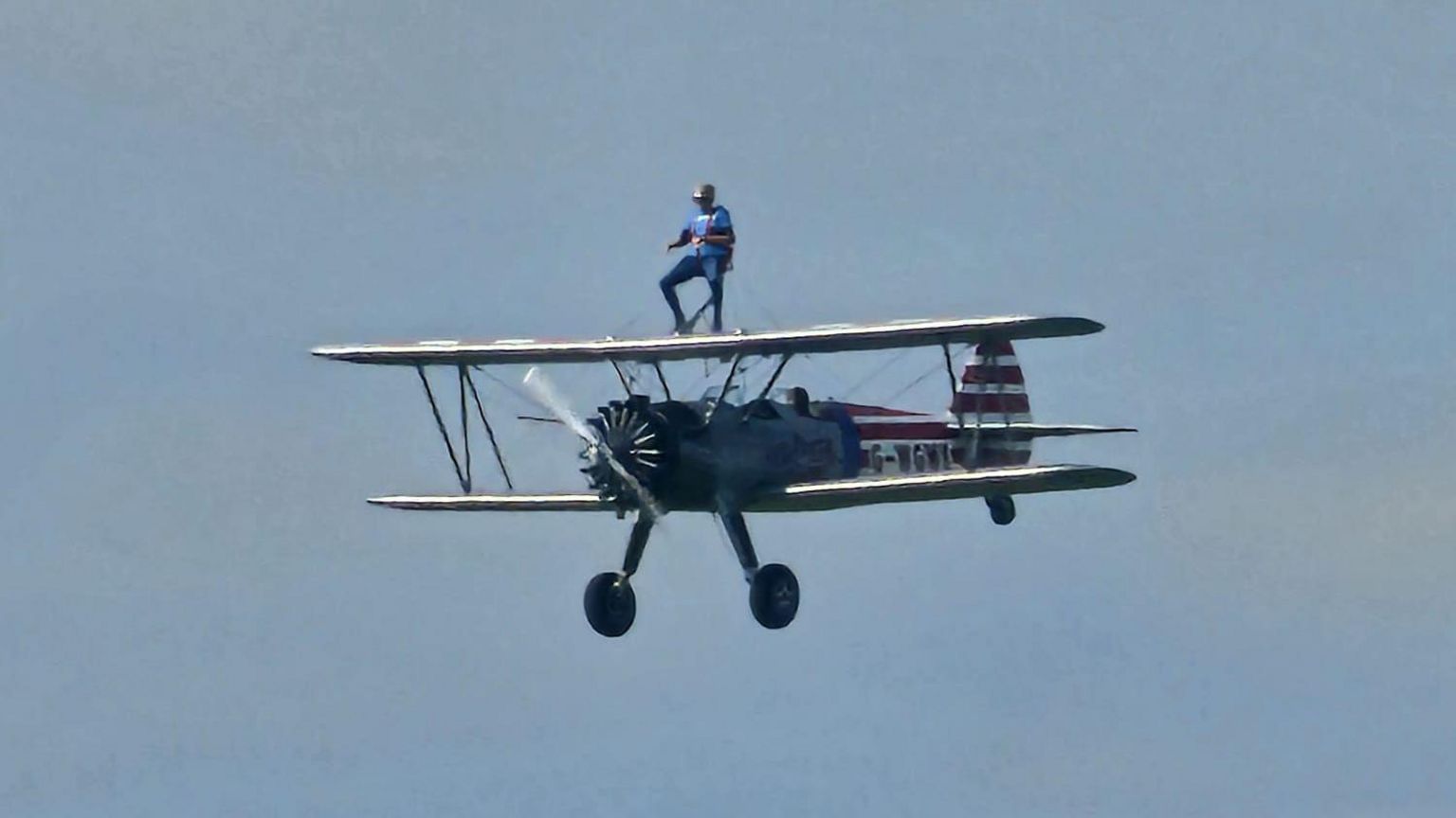 Woman wing-walking on a biplane in flight