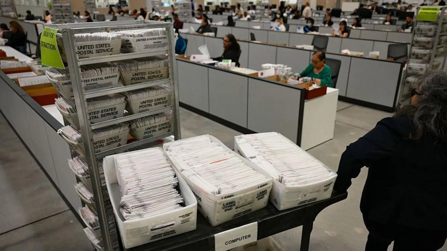 AFP An election worker moves mail-in ballots to be organised for tabulation at the Los Angeles County Ballot Processing Center during California's state primary election in the City of Industry, Calif
