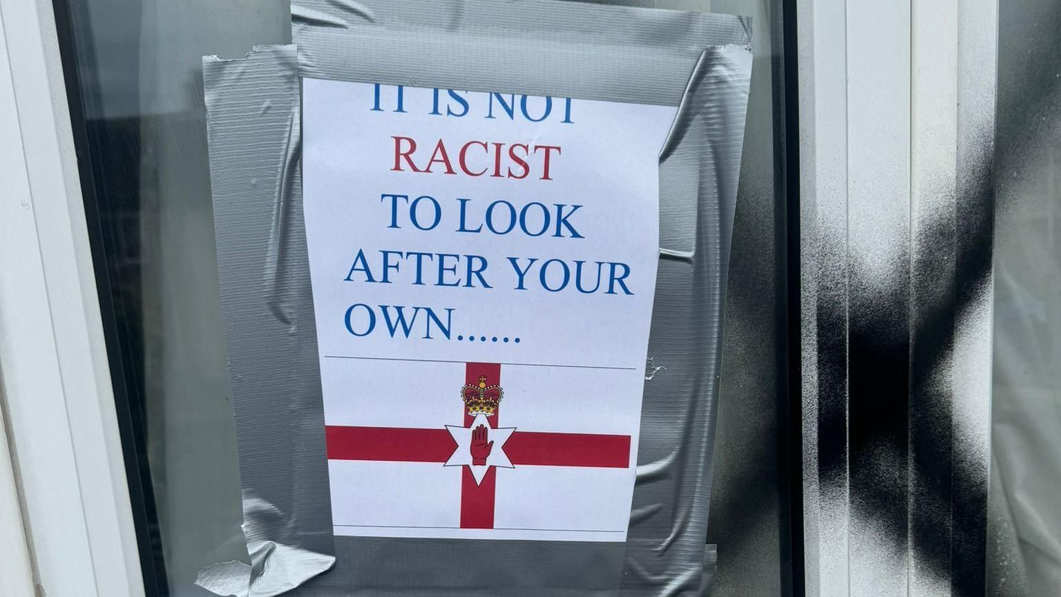 A sign taped to the window read: "It is not racist to look after your own..."