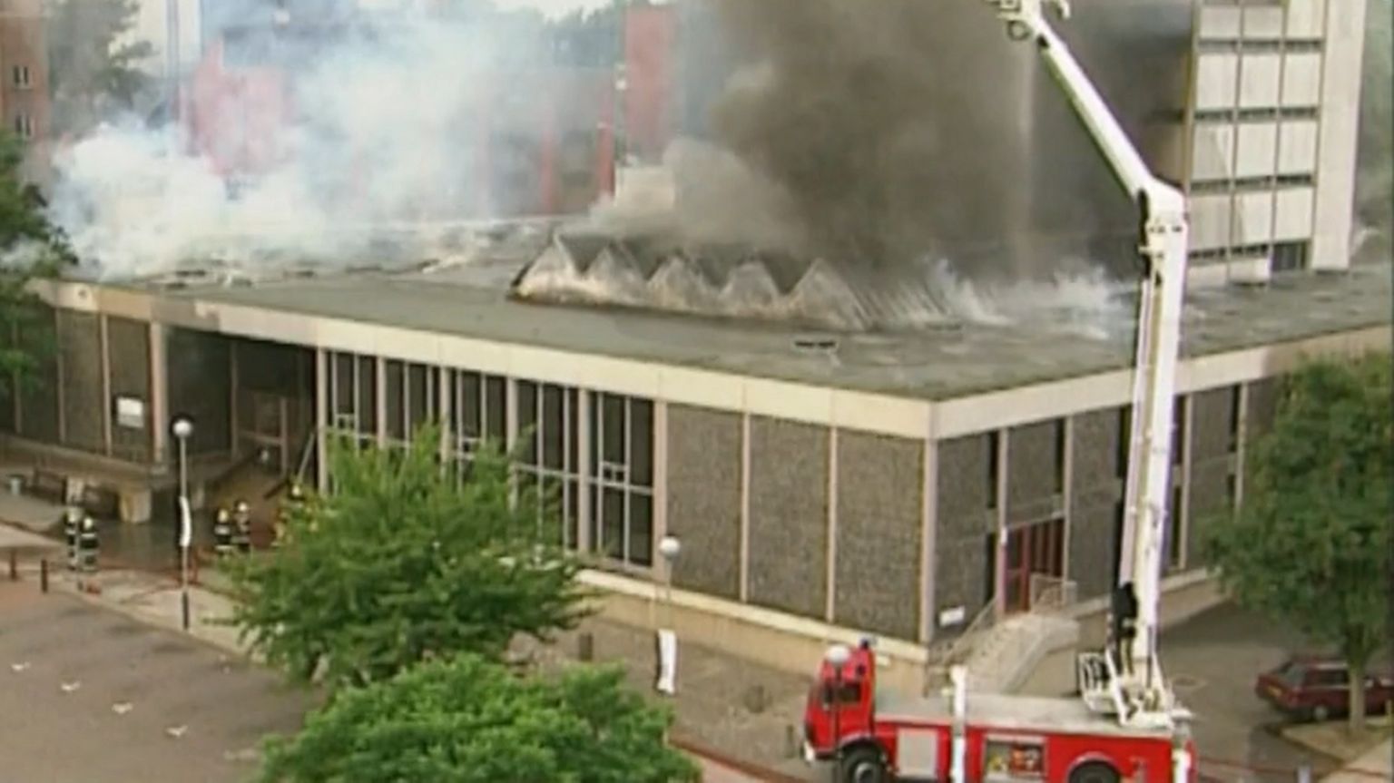 A fire engine and firefighters in front of Norwich Central Library, which is on fire