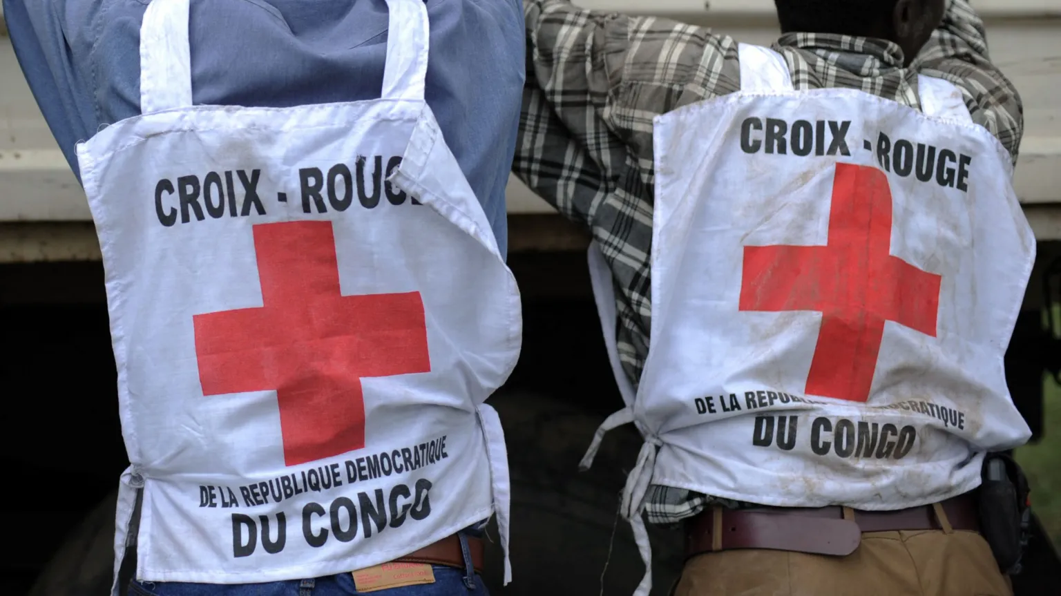 AFP via Getty Images Two individuals are pictured from behind wearing Red Cross tabards.The tabards read "croix-rouge de la republic Democratique du Congo"