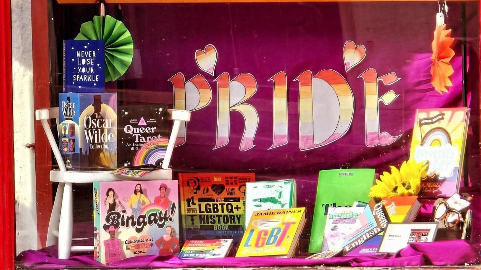 Shop window with word Pride in background and books on display