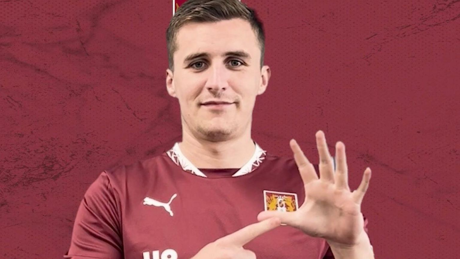 Man in Northampton shirt using sign language