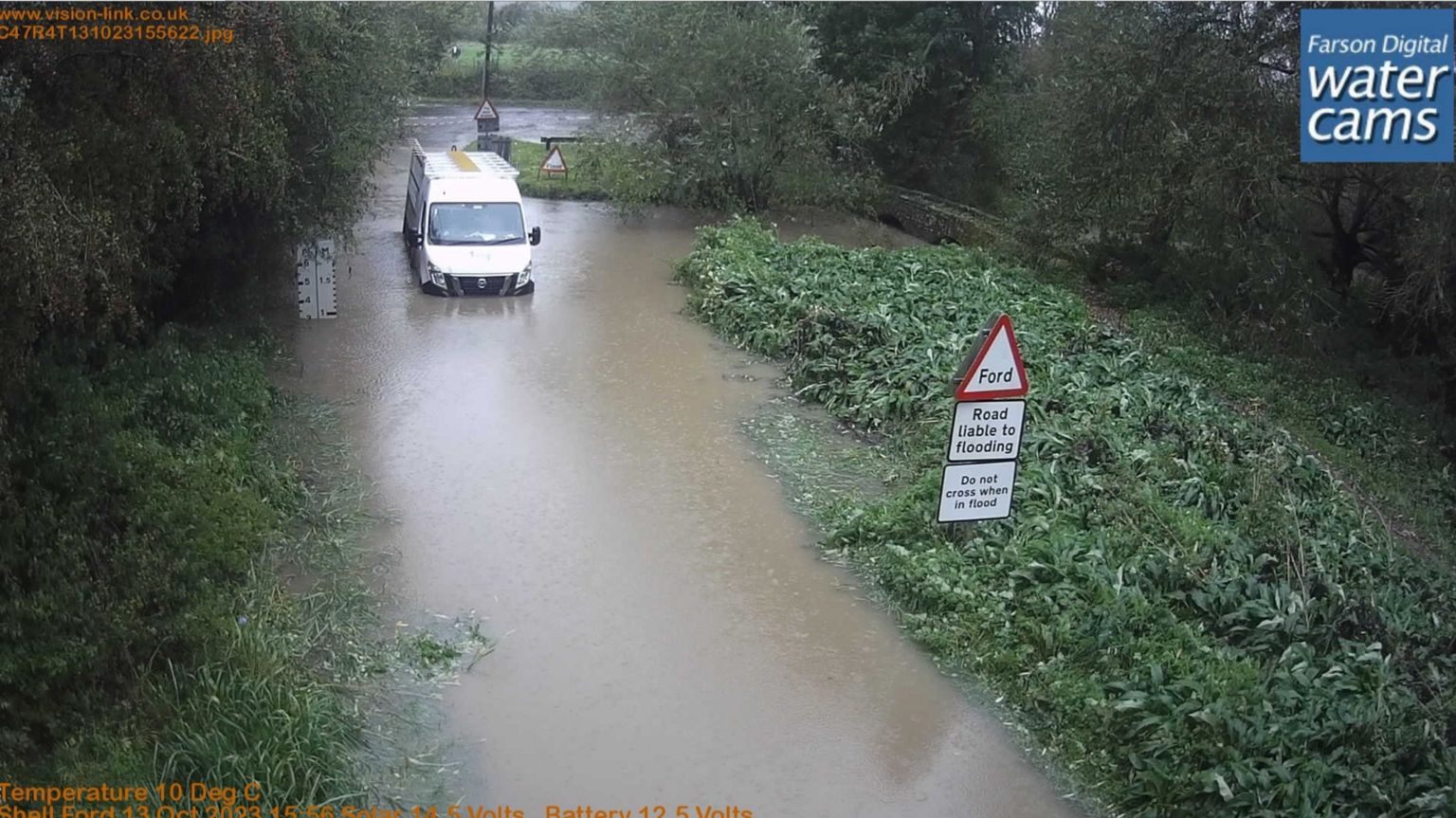 A white van surrounded and stuck in water