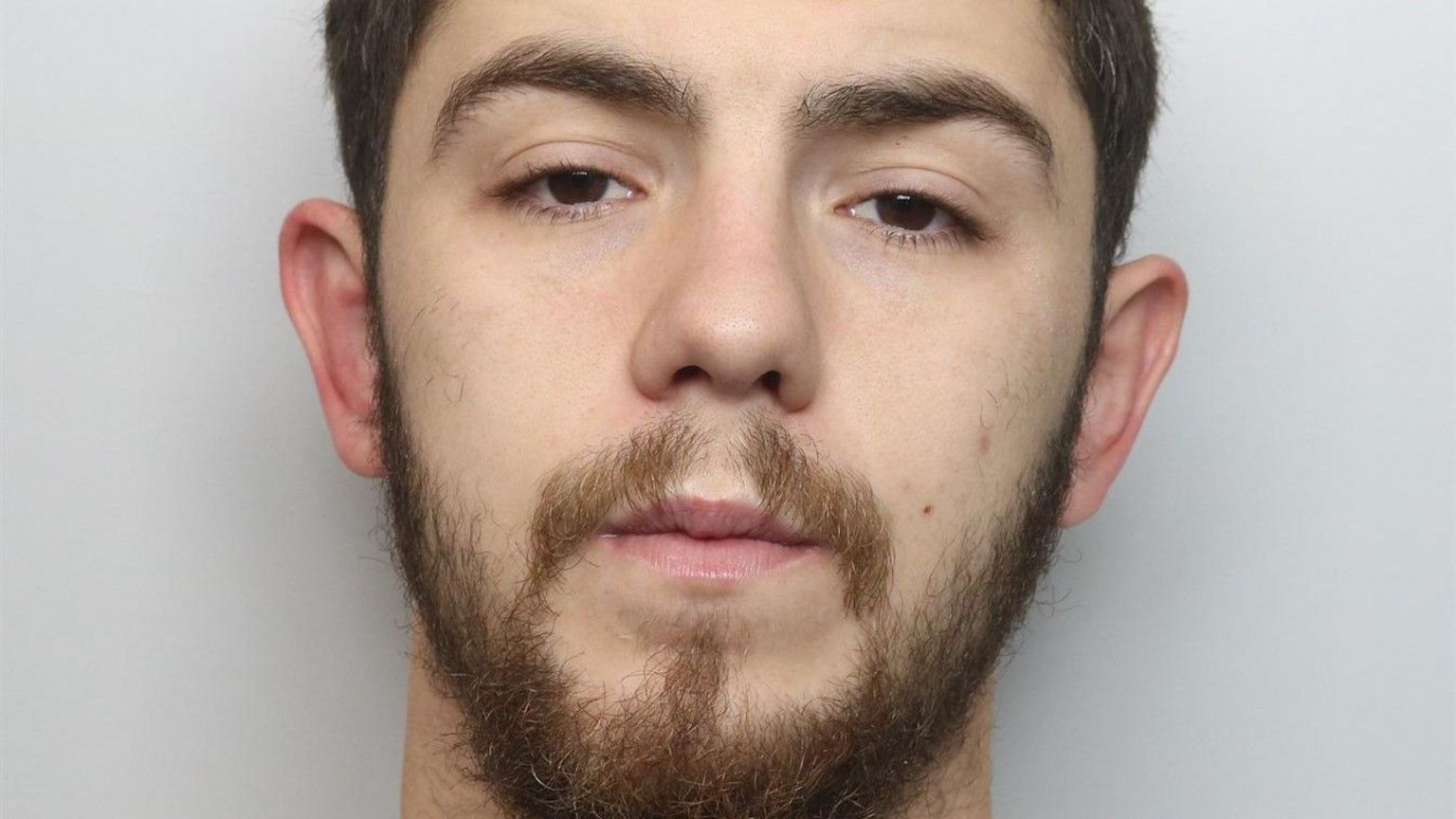 Police headshot of Marcus Ramsden. He is looking at the camera and has brown hair and a beard. 