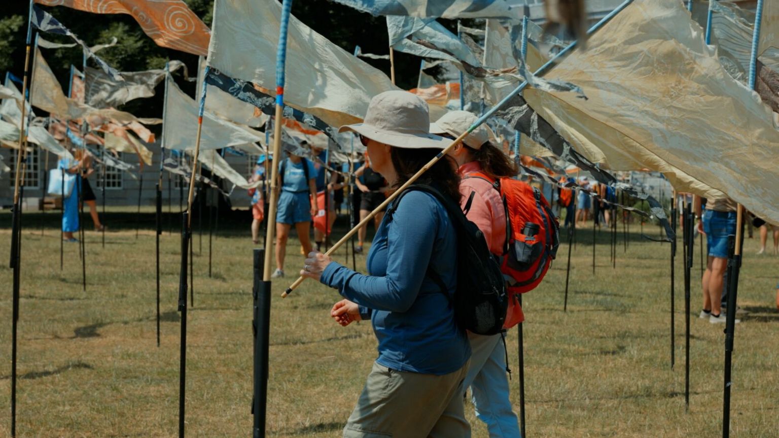 People walking through area with flags in the ground i