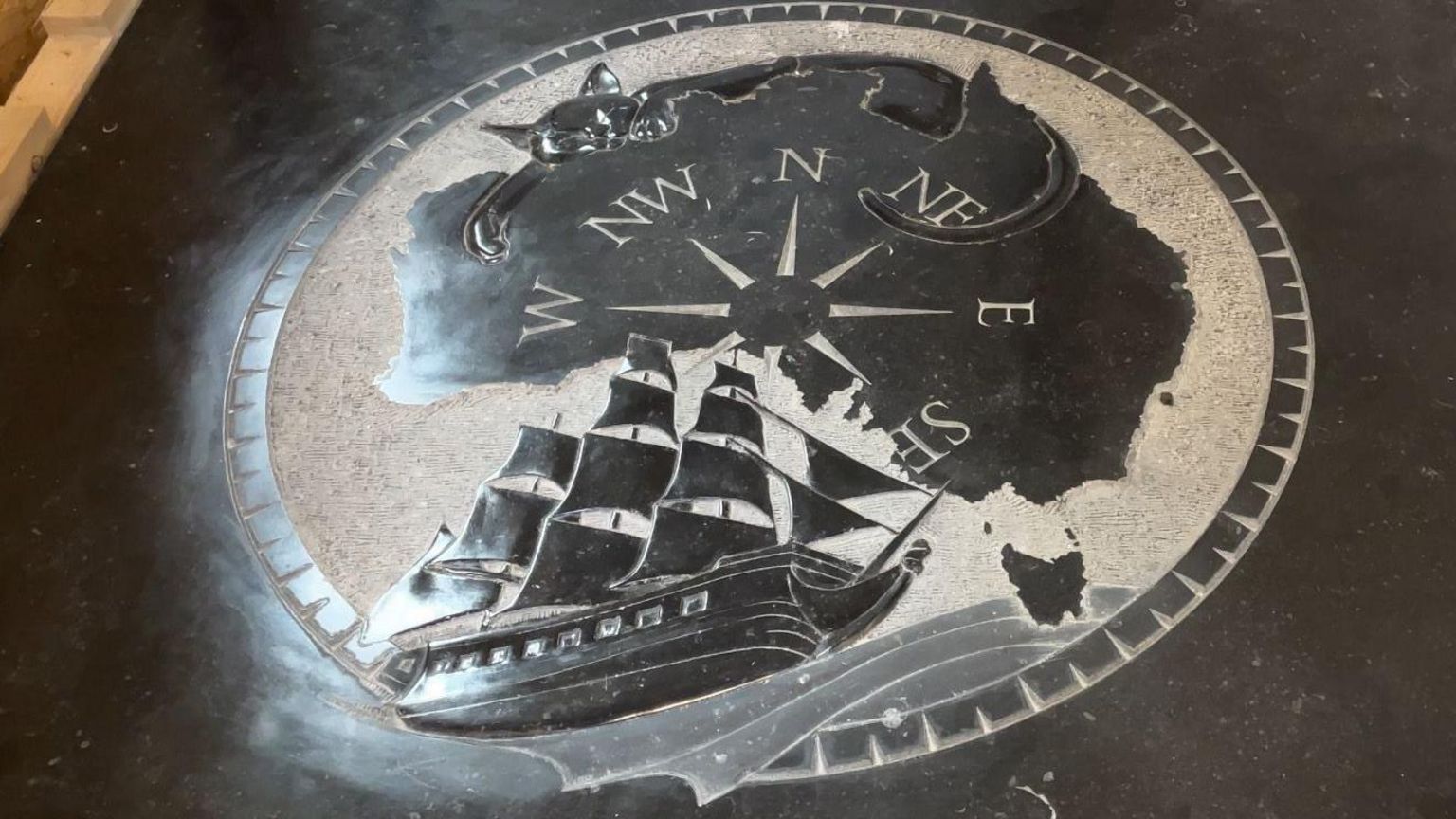Picture of black marble featuring an engraving of Australia, the HMS Investigator and Captain Matthew Flinders's cat Trim