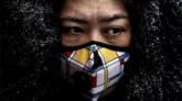 Una mujer china usa una máscara protectora mientras compra en un mercado el 6 de febrero de 2020 en Beijing, China.