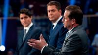 Yves-François Blanchet speaks as Justin Trudeau and Andrew Scheer watch