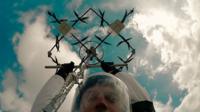 Man prepares to parachute from a drone