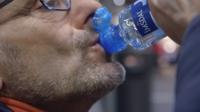 A man drinks from a bottle