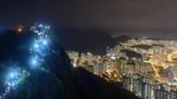 People light up mobile phones on Lion Rock above Hong Kong as part of a human chain of protest
