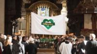 A Grenfell banner being carried into the cathedral
