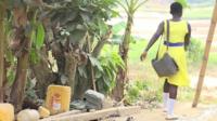 Ghanaian schoolgirl walking across river