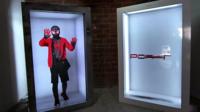 A person in a superhero costume projected into a Portl box