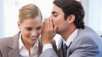 People whispering in office