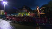 Workers repair the water pipe under floodlights