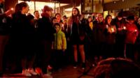 People sing at a vigil