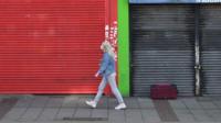 A person walking past closed shops in east London on 2 May