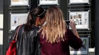 Women look at estate agent window