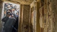 Journalists enter a newly-discovered tomb at the Saqqara necropolis, 30 kilometres south of the Egyptian capital Cairo