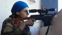 Female Kurdish fighter takes aim from hiding place