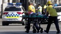 Police officers and emergency service workers move an injured man, after a van crashes into pedestrians in Las Ramblas, downtown Barcelona, Spain, 17 August 2017
