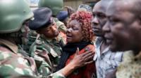 A Kenyan police officer comforts a relative at the scene where seven Kenyan teenage schoolgirls died and 10 more were hospitalized after a fire engulfed their boarding school dormitory in Nairobi, Kenya September 2, 2017