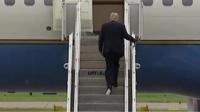 Trump boarding a plane with paper stuck to his shoe