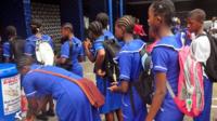 Students wash hands before entering school in Liberia