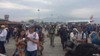People stand on the runway outside the International Terminal after a earthquake hit, at Tribhuvan International Airport, Kathmandu, Nepal, April 25, 2015,