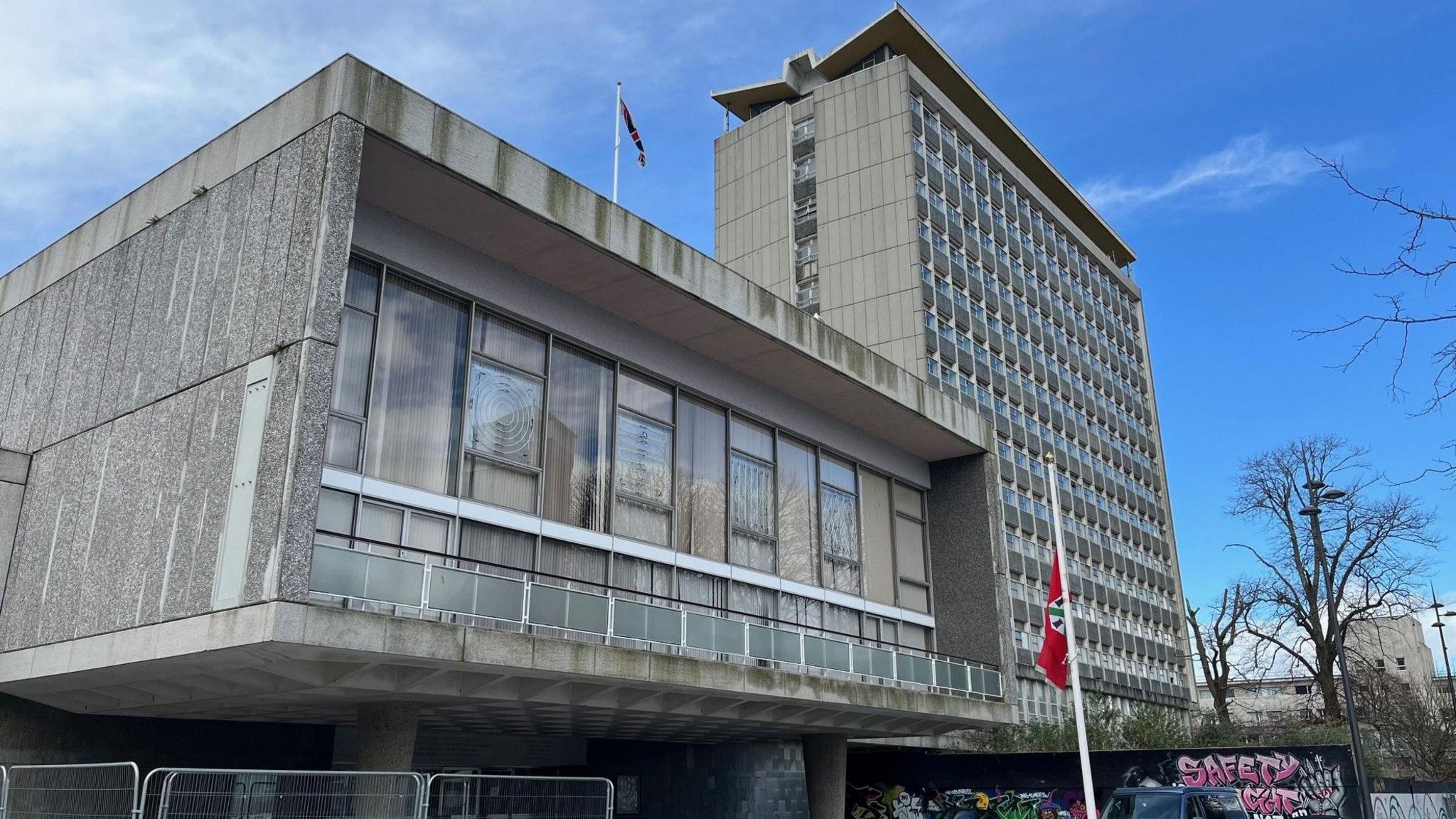 The Civic Centre buildings in Plymouth, with the city council's debating chamber pictured on the left. The chamber is housed in a single-storey 1960s concrete structure on one-story high concrete pillars