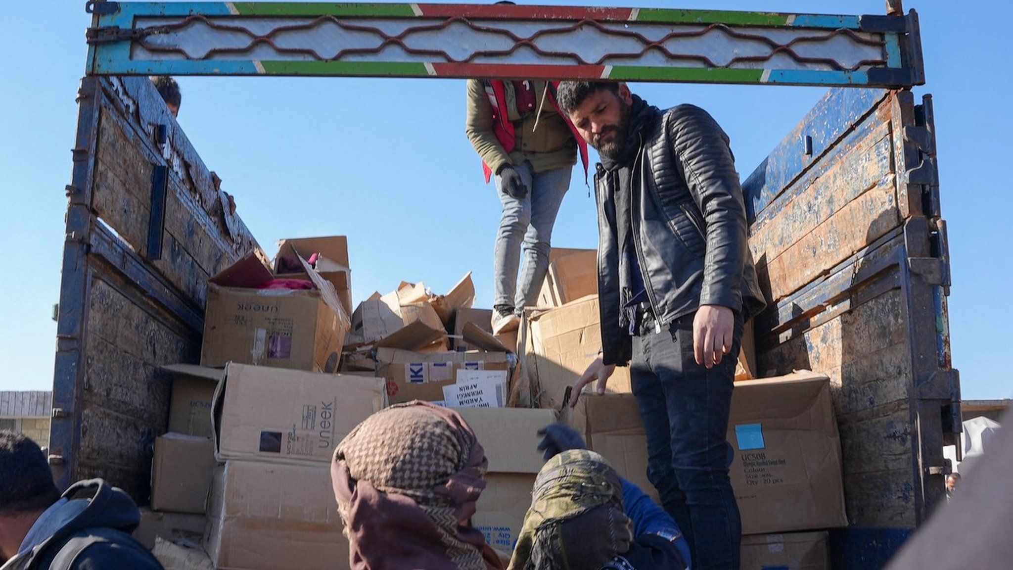 File photo showing Syrians receiving aid at a make-shift shelter near the opposition-held town of Jinidayris (9 February 2023)