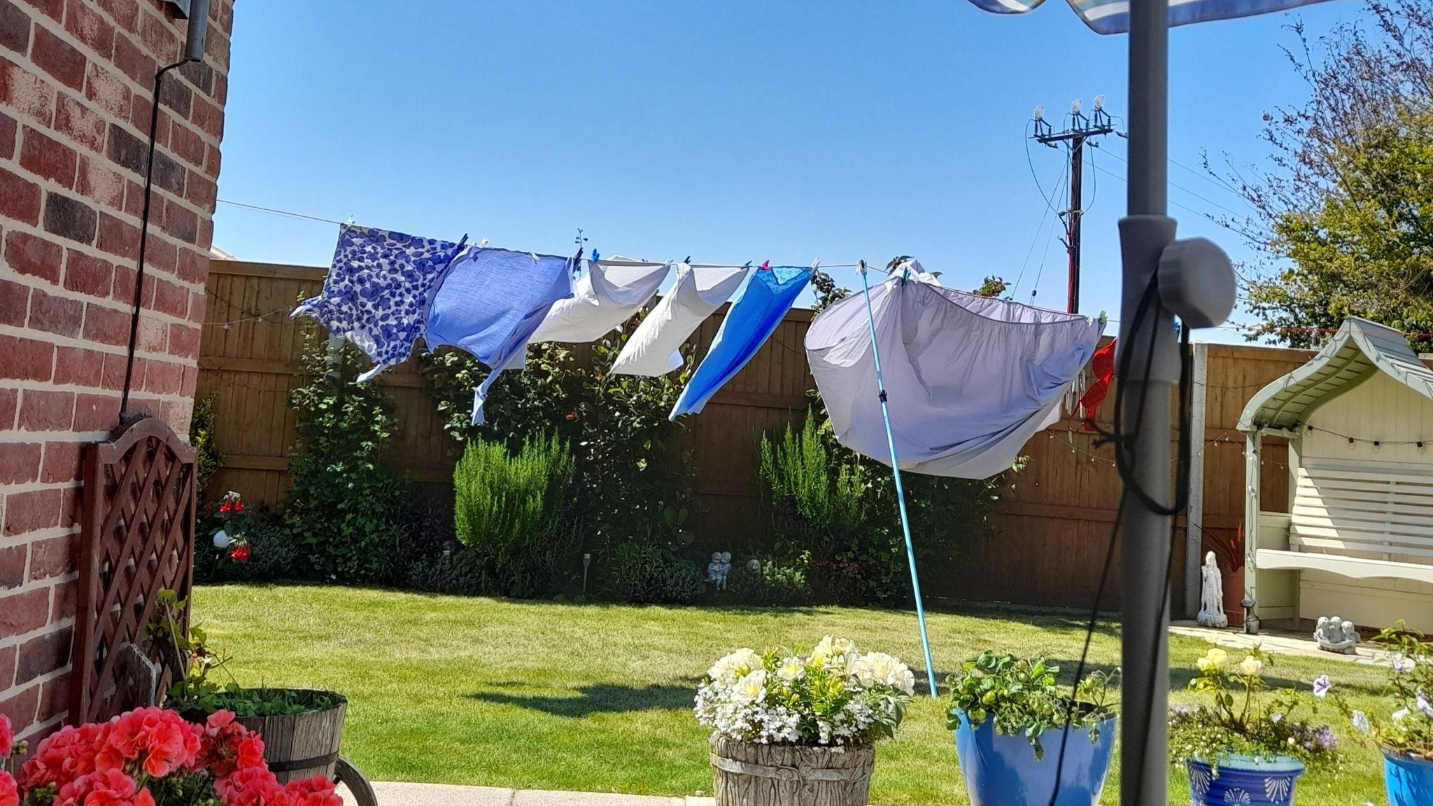 Washing on a line drying in the sun in someone's back garden