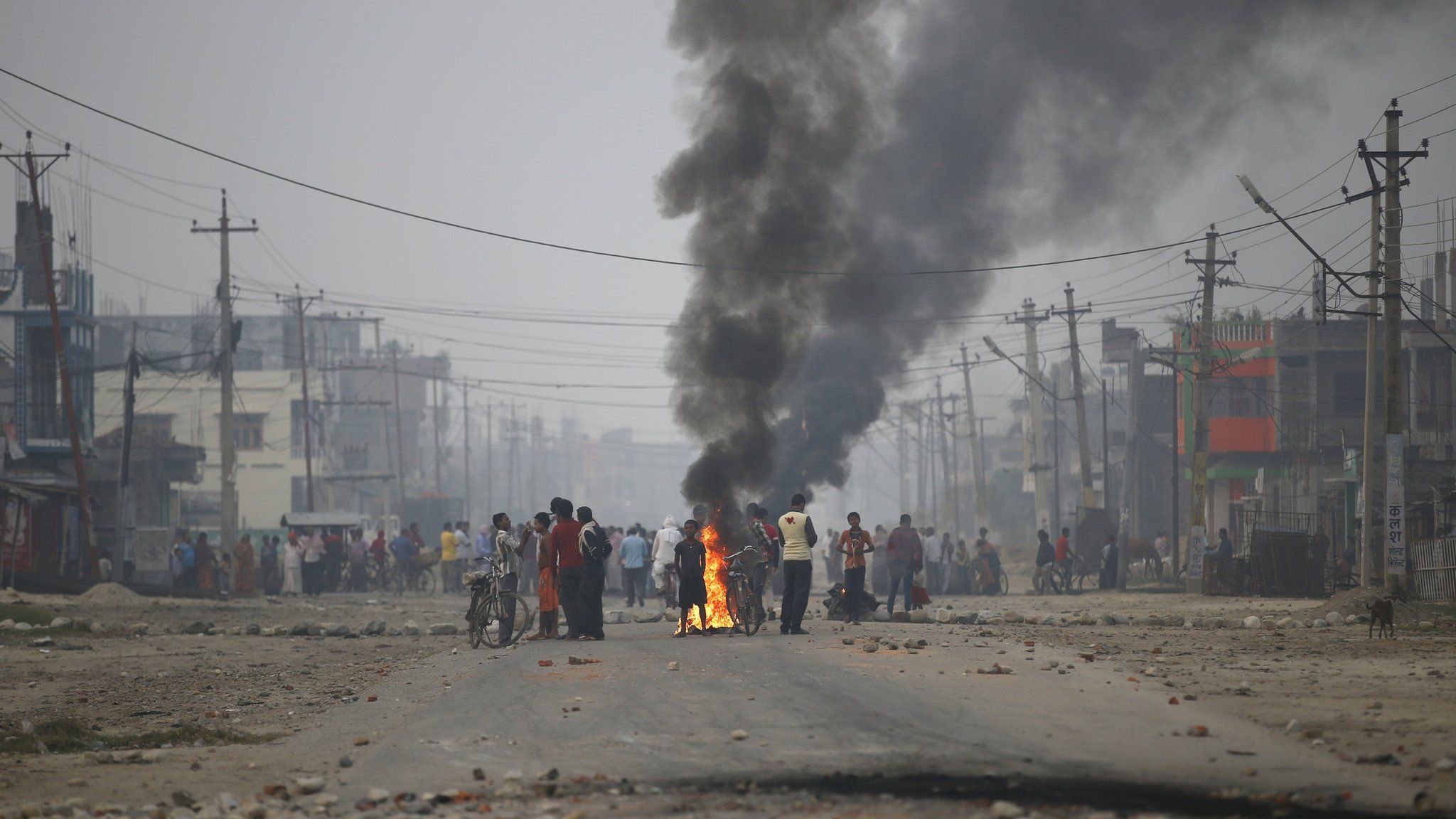 Protesters stand near burning tyres as they gather to block the highway connecting Nepal and India during a general strike called by Madhesi protesters earlier in November