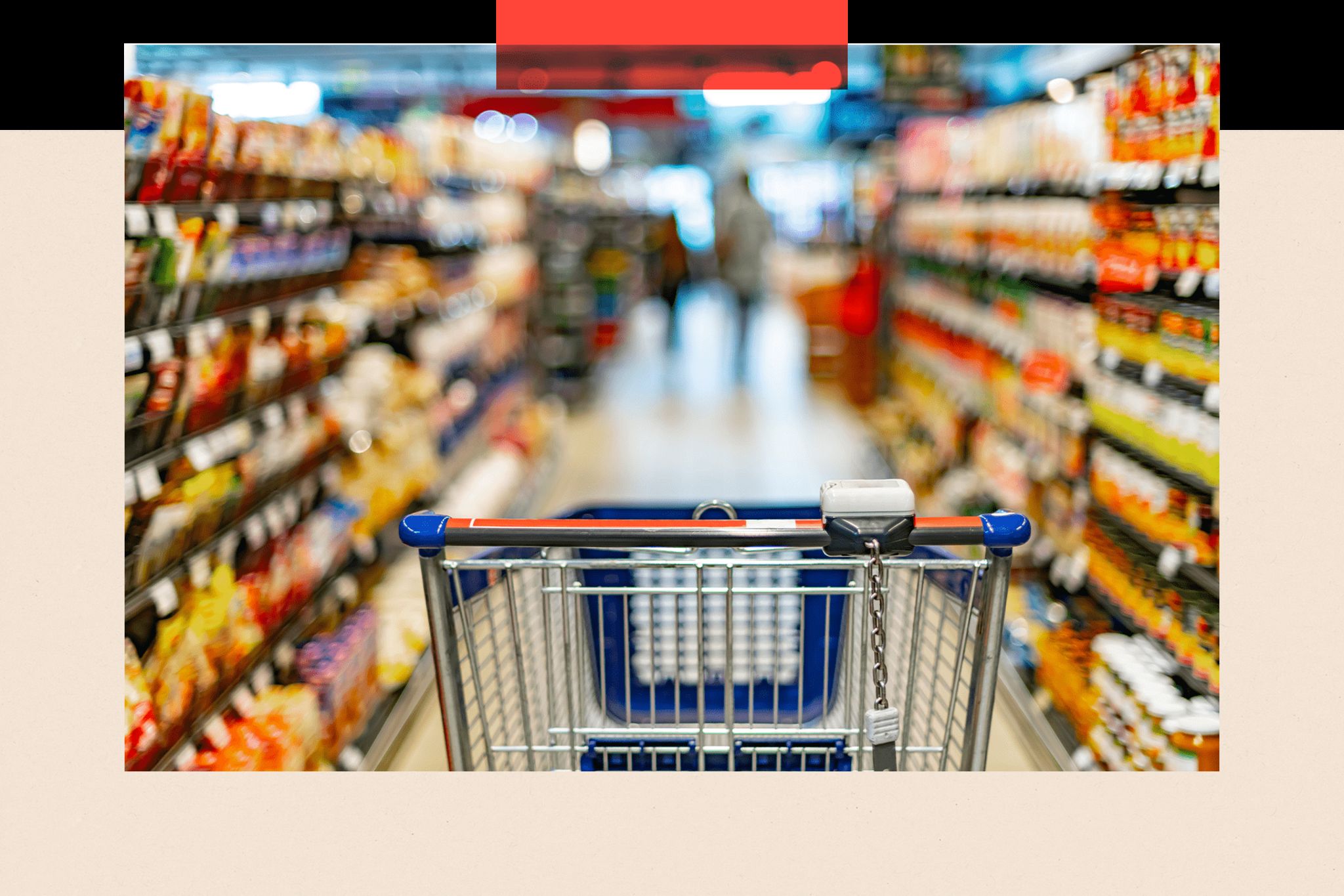 A shopping cart in the aisle of a supermarket