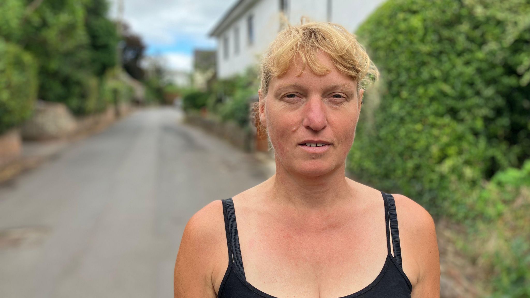 Woman standing in village road with cottages in the background