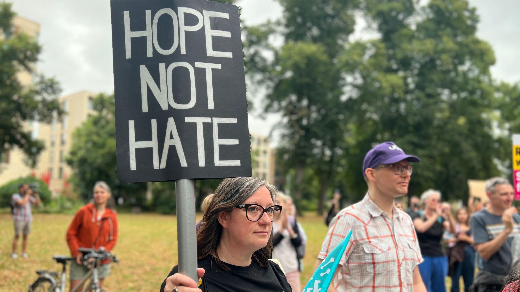 A woman holding a board reading "Hope not hate"