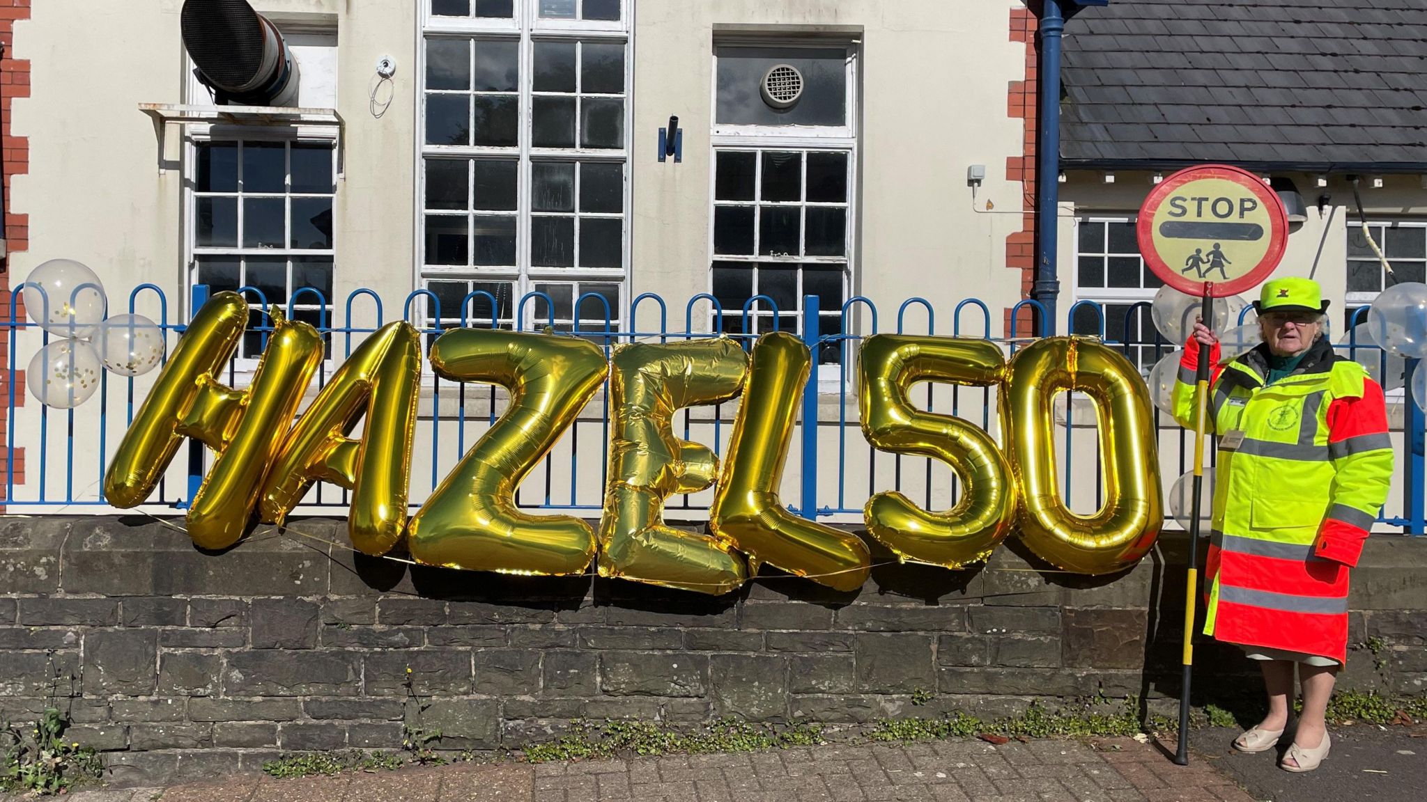 Hazel Davies with celebration balloons outside school