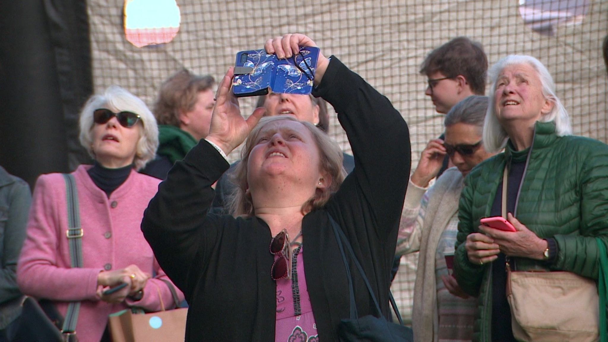 A woman takes a photograph of the abseilers