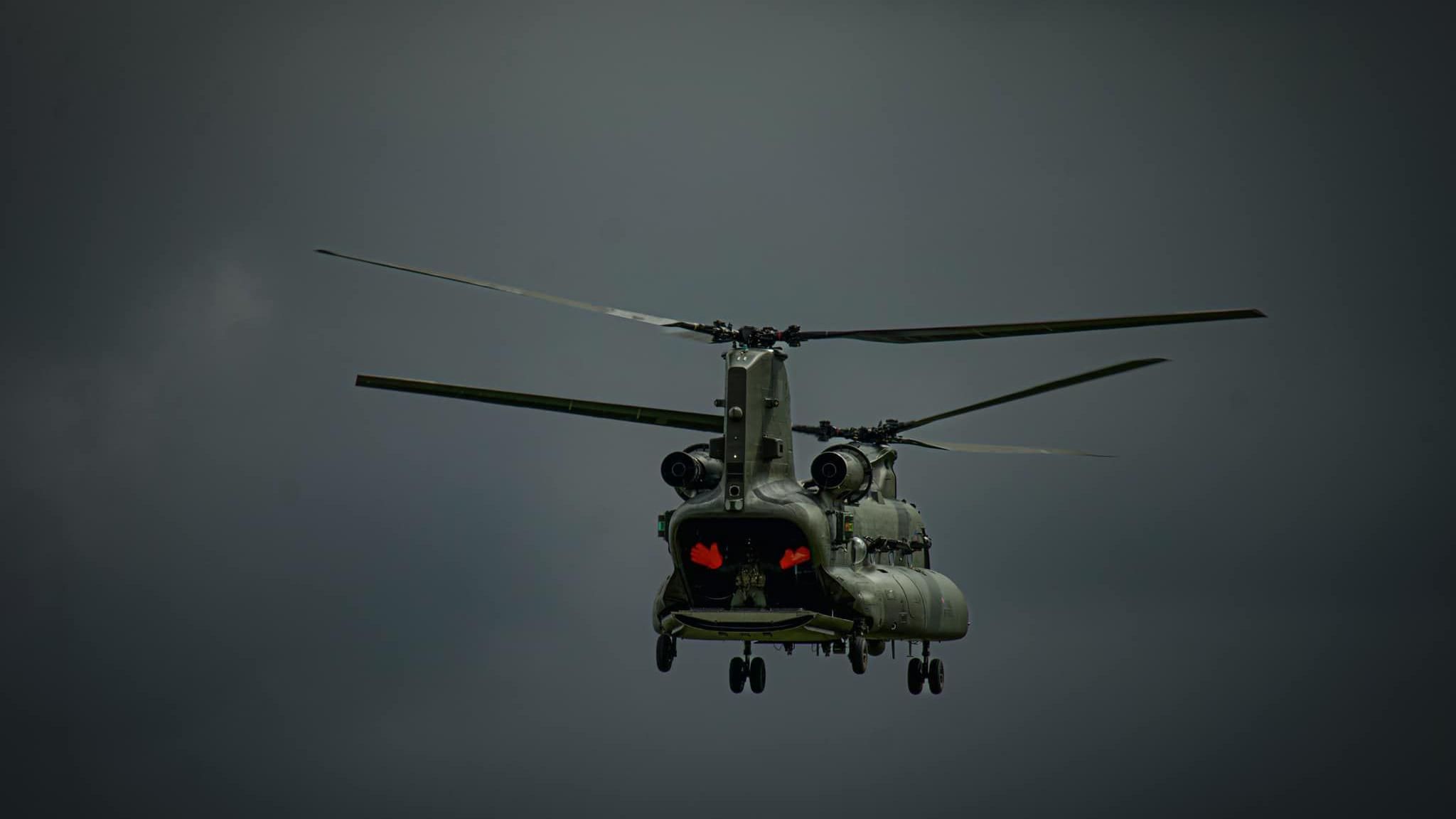 A helicopter hovering in the grey sky