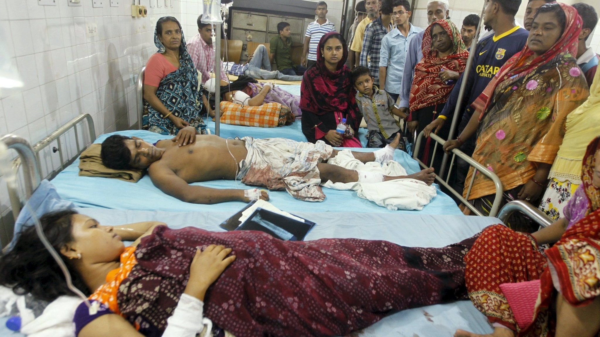 People who sustained injuries in a series of blasts are surrounded by their relatives at a hospital in Dhaka on 24 October 2015