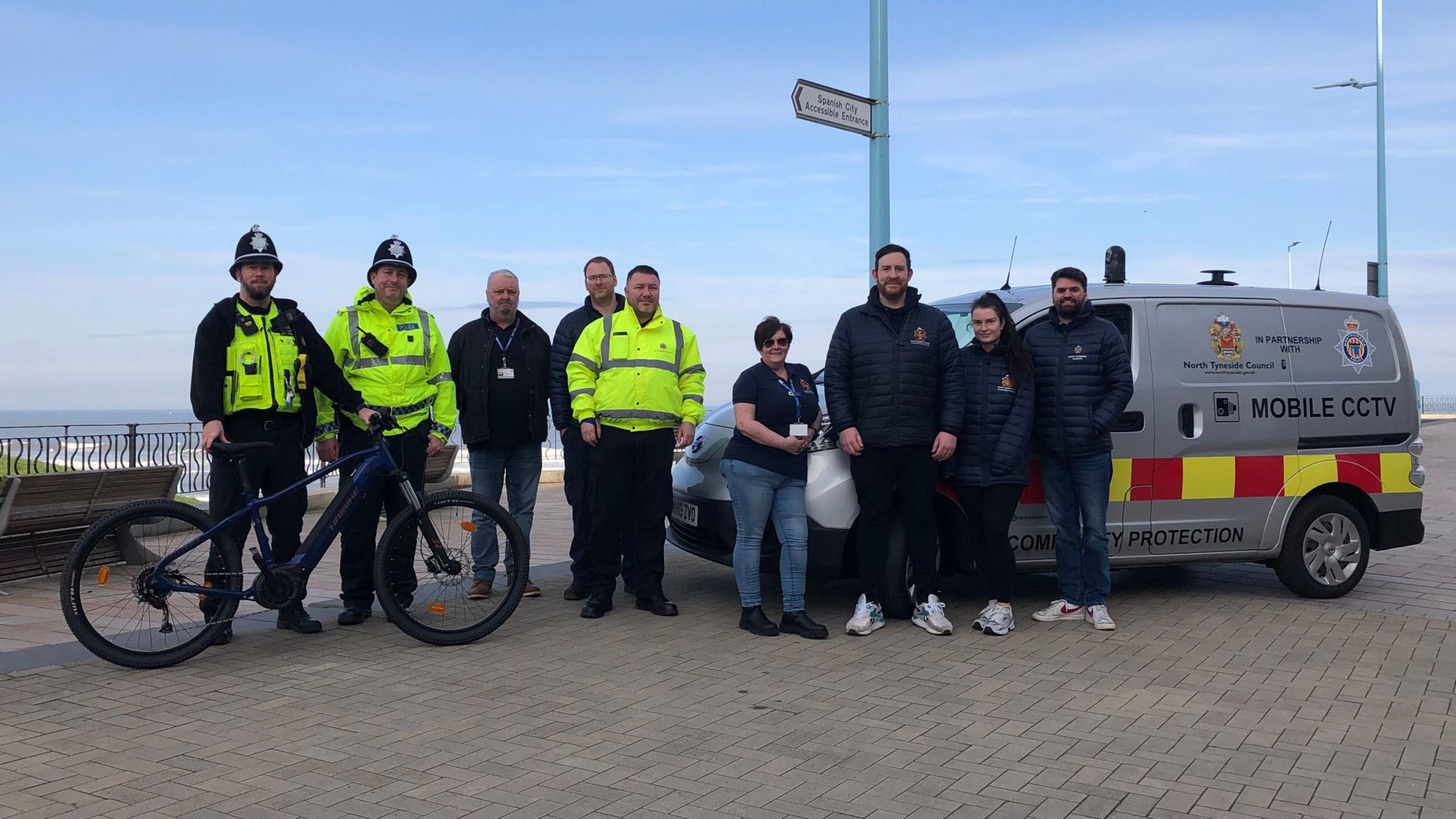 Northumbria Police officers in high vis, members of Nexus and North Tyneside council stood in front of the sea