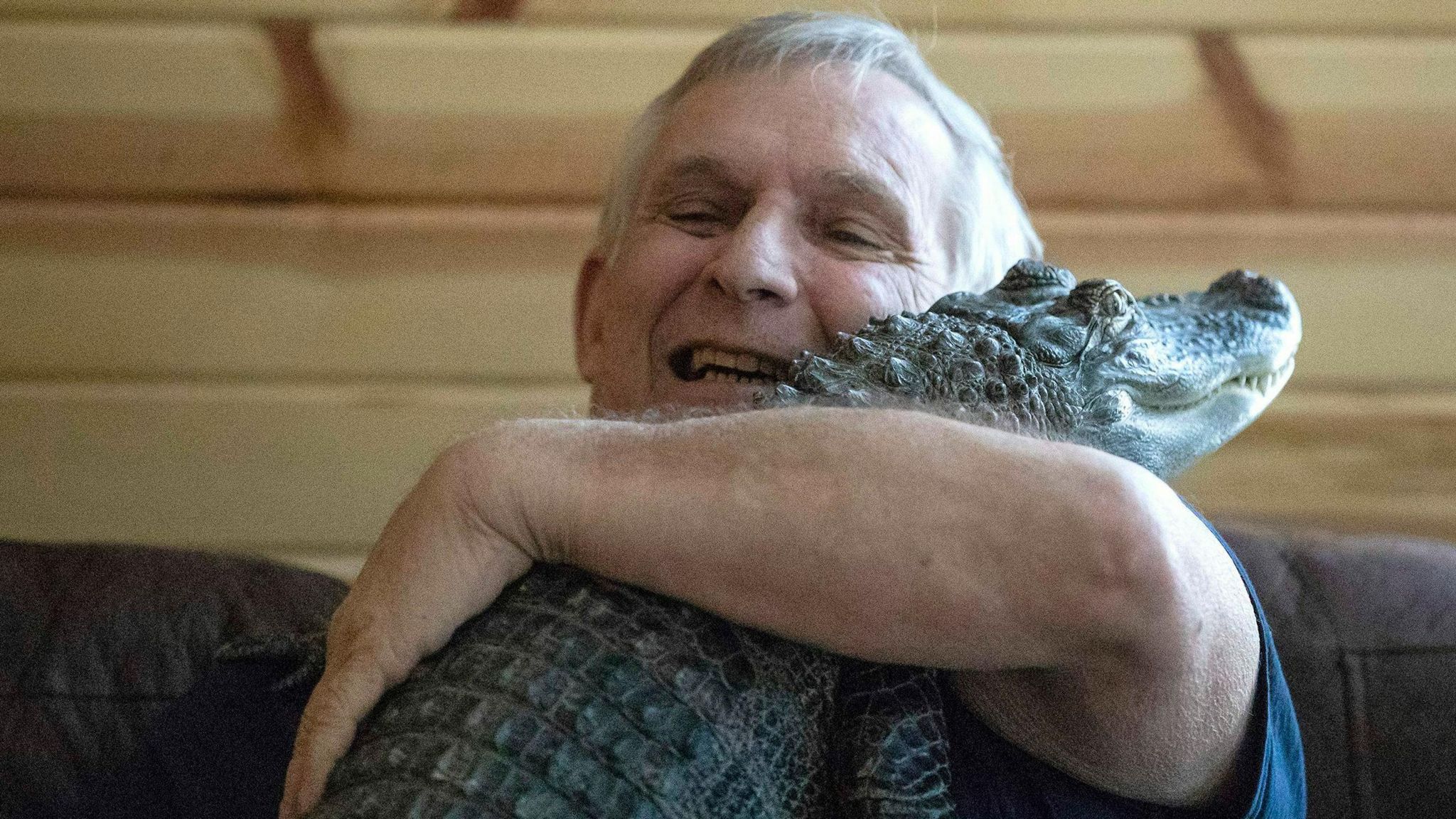Joie Henney, 65, hugs his emotional support alligator named Wally 
