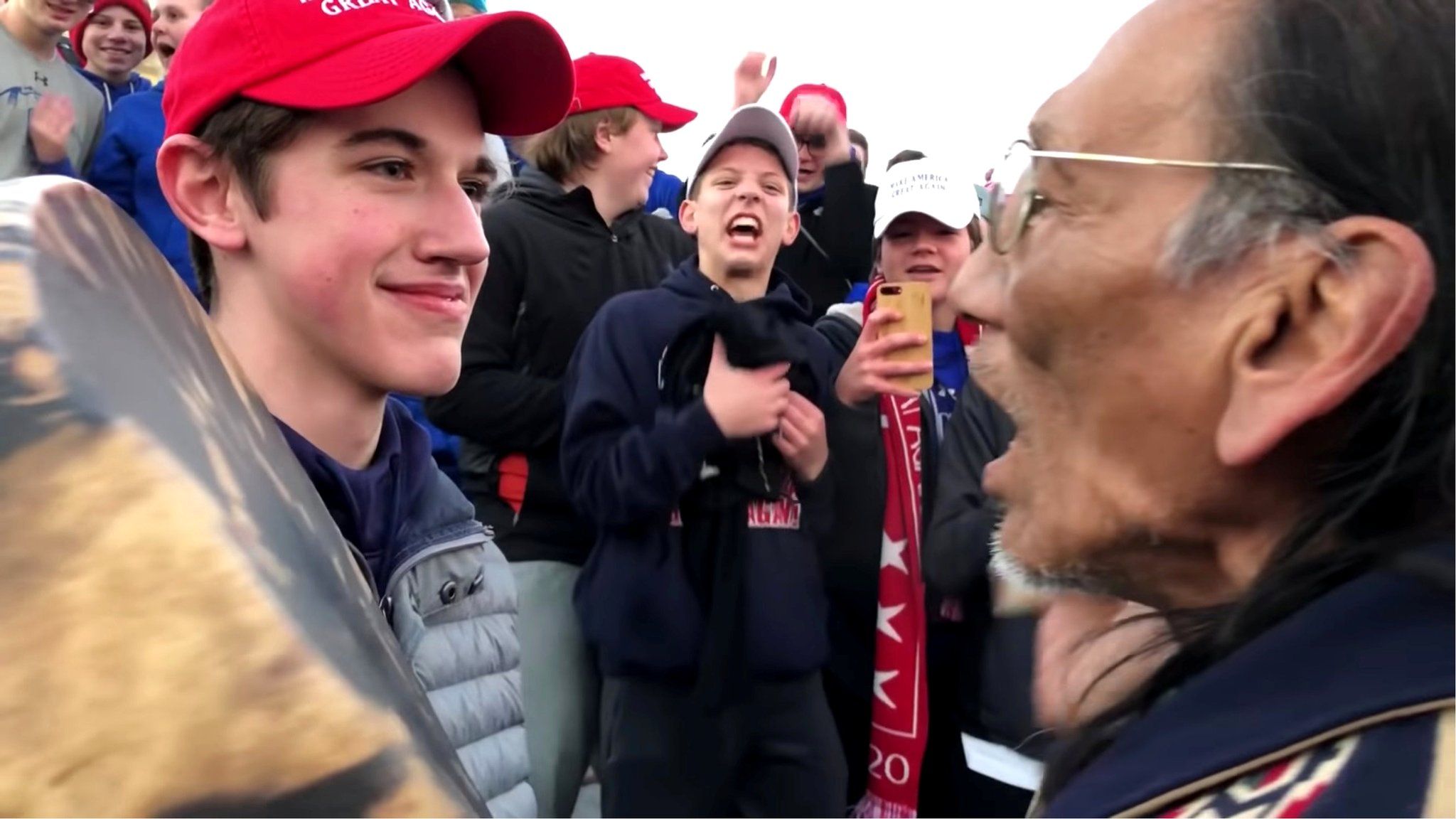 A student from Covington Catholic High School stands in front of Native American Vietnam veteran Nathan Phillips in Washington DC, 18 January 2019