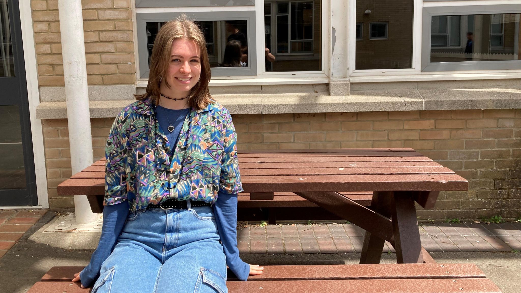 John Cabot student Jess sat on a picnic bench