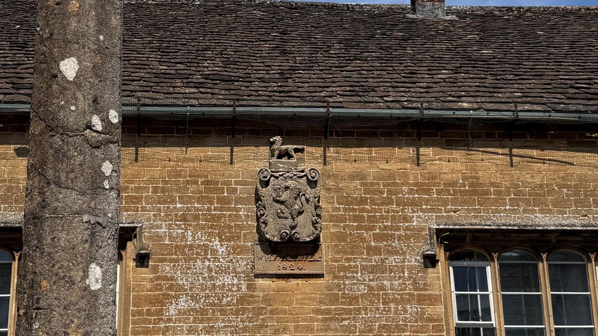 Lacock School in Wiltshire with an emblem of a lion with a plaque beneath it