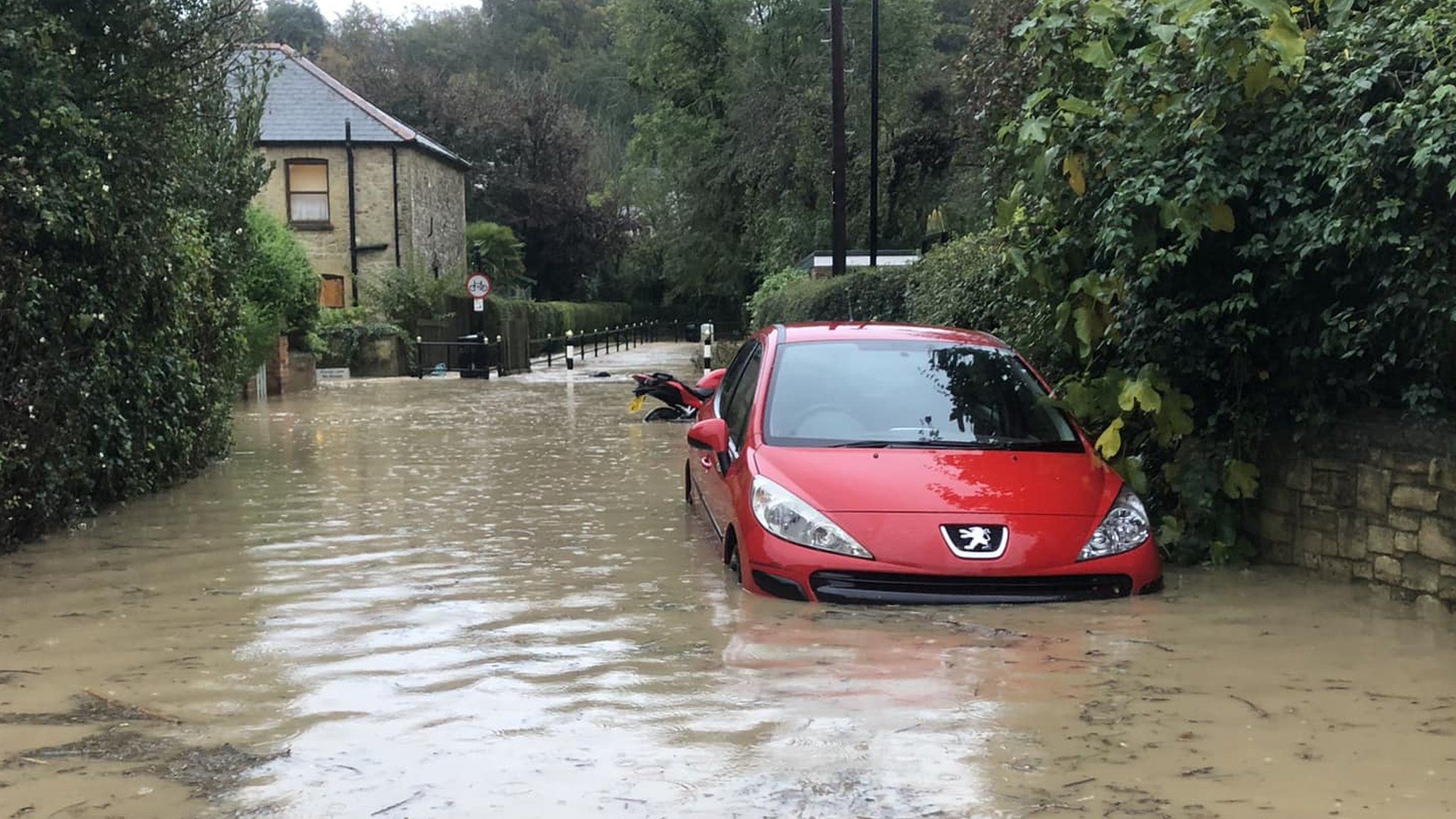 red car half submerged in water