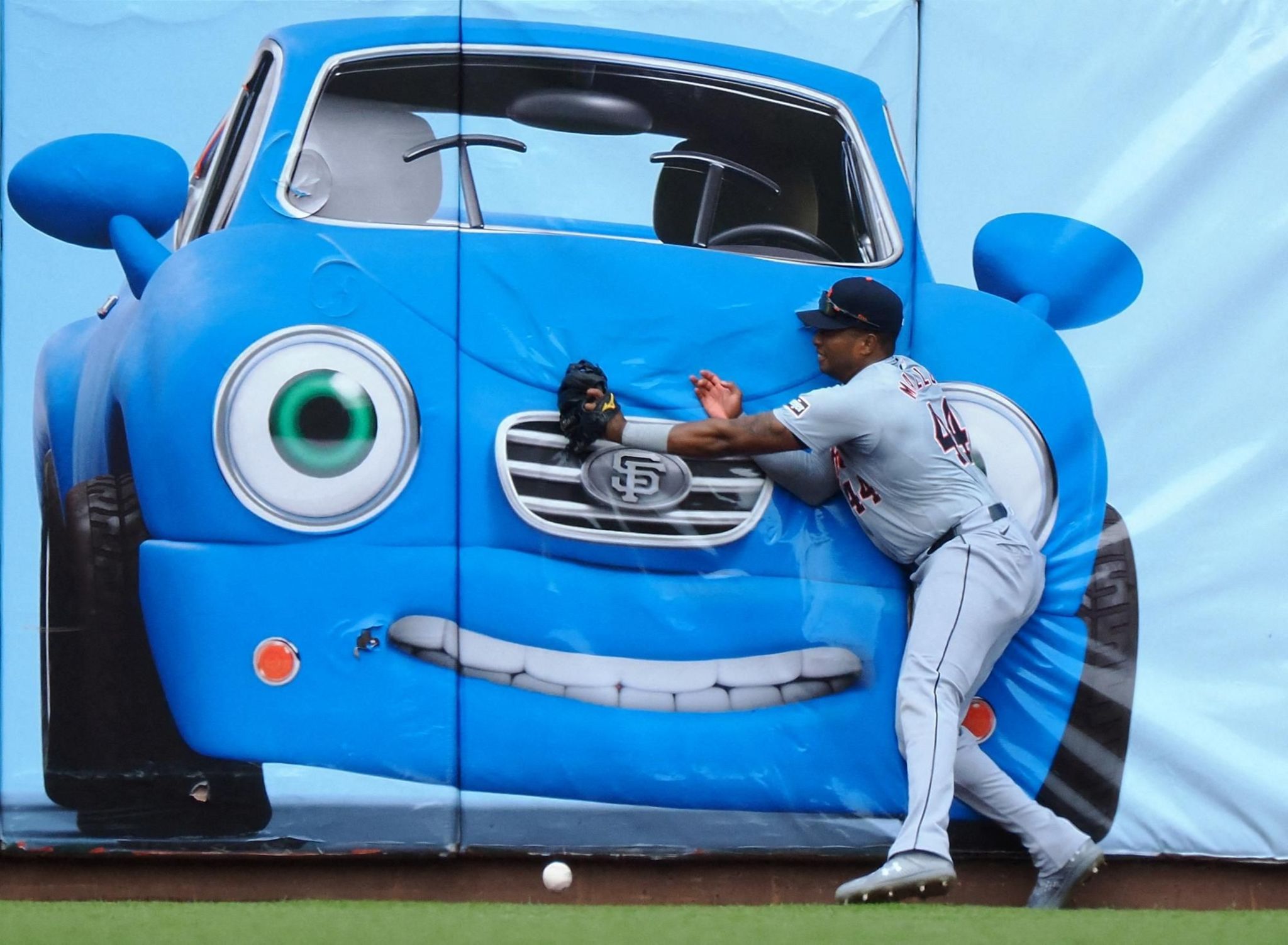 Detroit Tigers left fielder Justyn-Henry Malloy attempts to catch the ball in front of a painting of a car