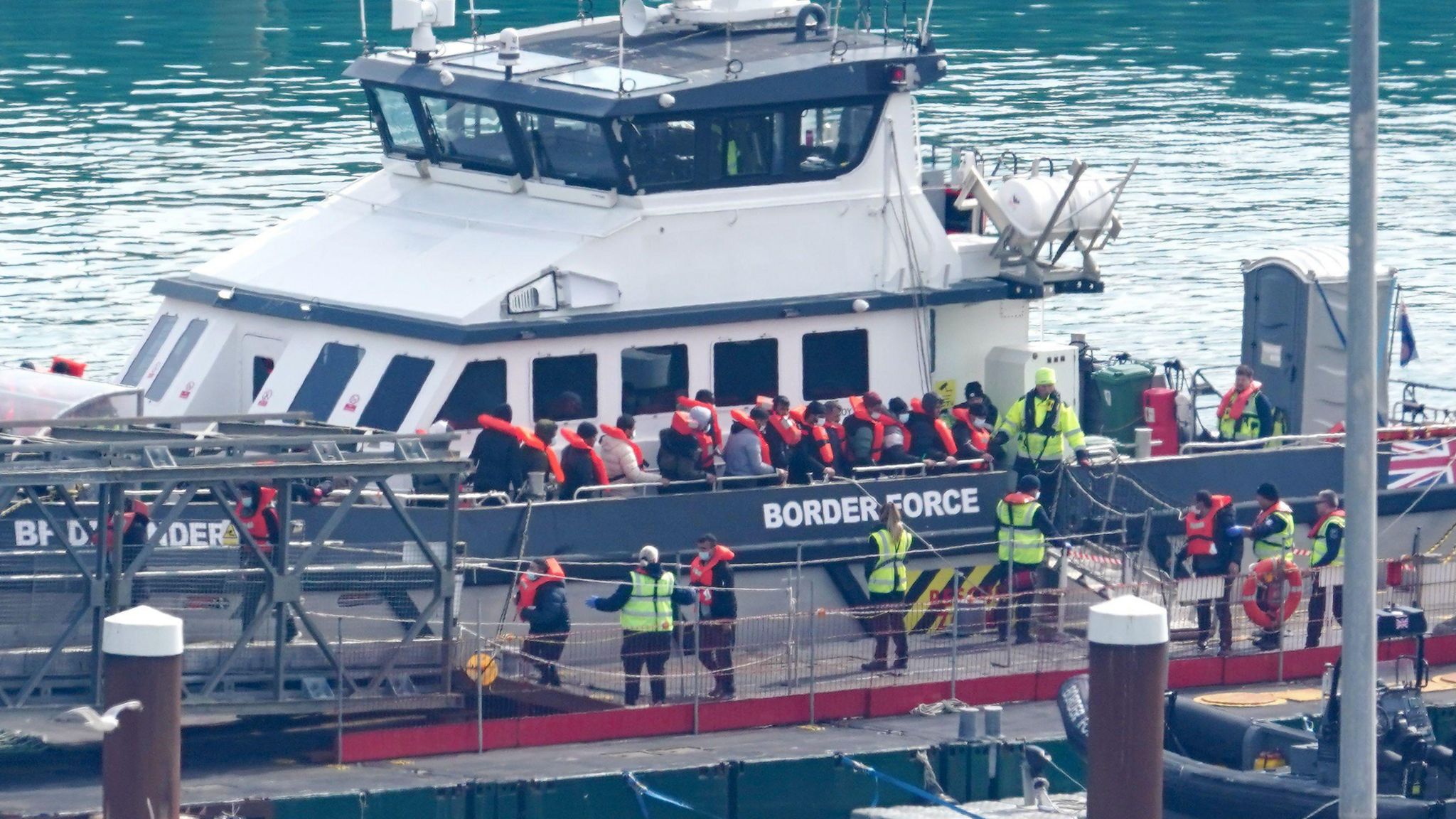 Migrants disembark a border force boat in Dover